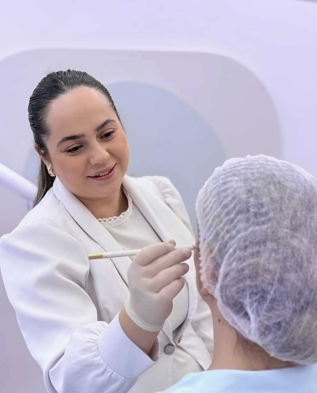 Dra. Lorayne sorrindo enquanto planeja a harmonização de uma paciente
